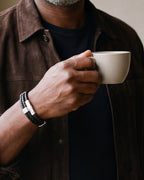 Close-up of the Atlas braided leather bracelet and its silver-tone clasp on a man's wrist