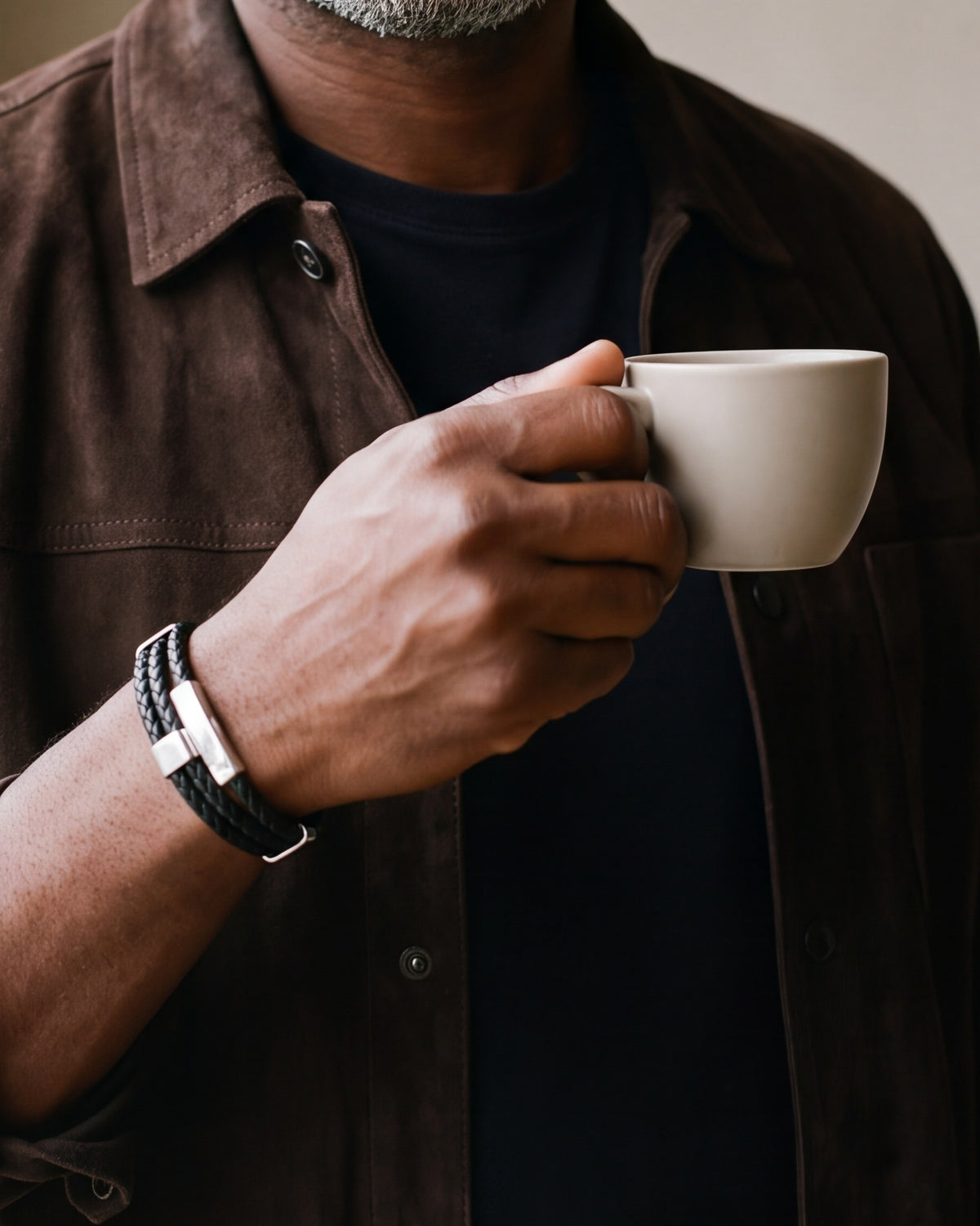 Close-up of the Atlas braided leather bracelet and its silver-tone clasp on a man's wrist