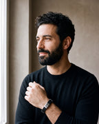 Man in a black merino sweater by a window wearing the Atlas braided leather bracelet