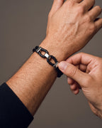 Hand adjusting the Atlas Braided Leather Shackle Bracelet on the wrist