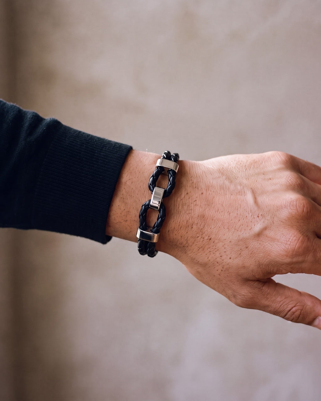 Close-up of the black Atlas Braided Leather Shackle Bracelet worn by a man, shown at true size