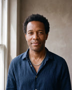 Man in a navy linen shirt by a window wearing the Atlas braided wheat chain in silver-tone steel