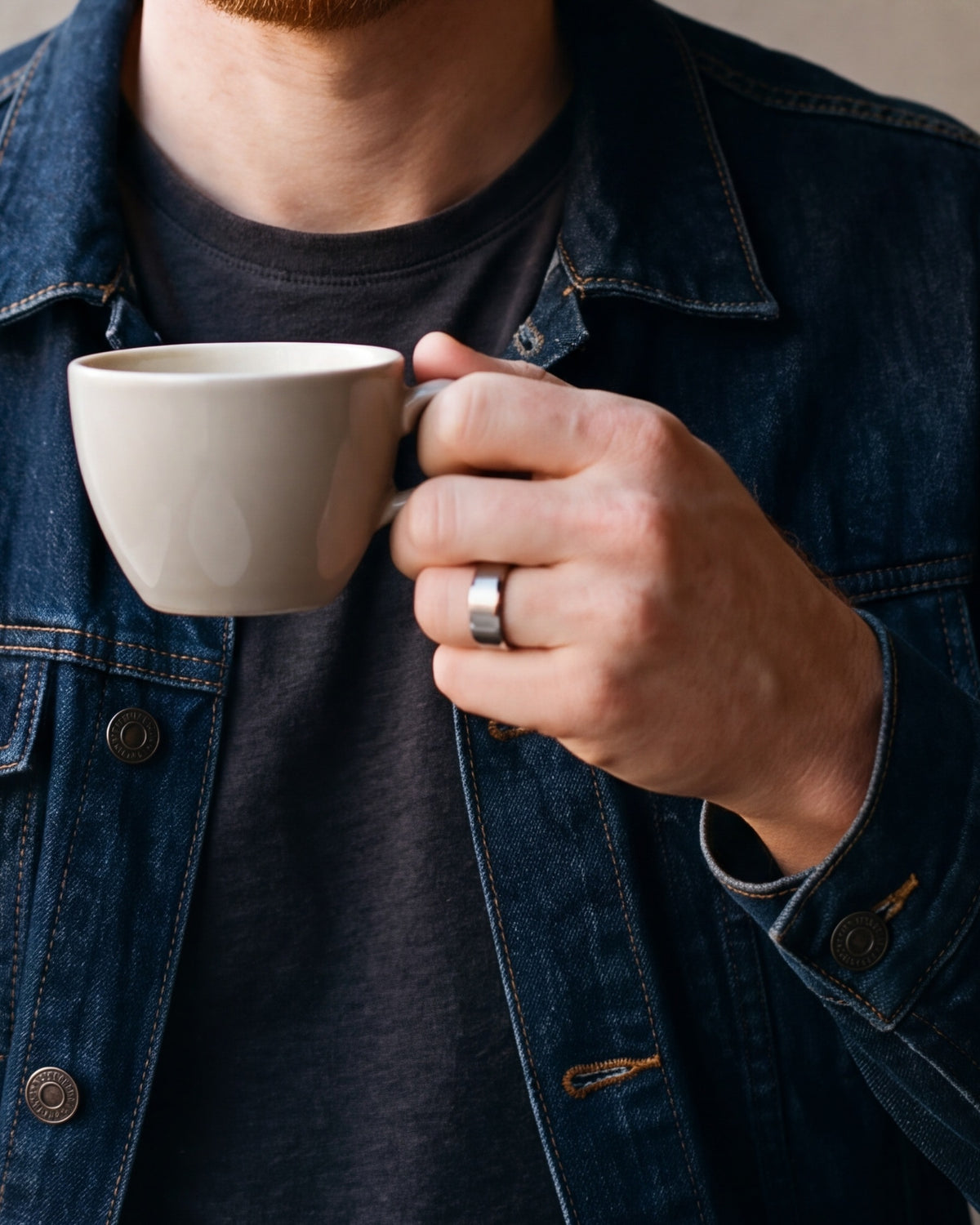 Close-up of a man's hand wearing the silver Atlas brushed beveled band ring at true size
