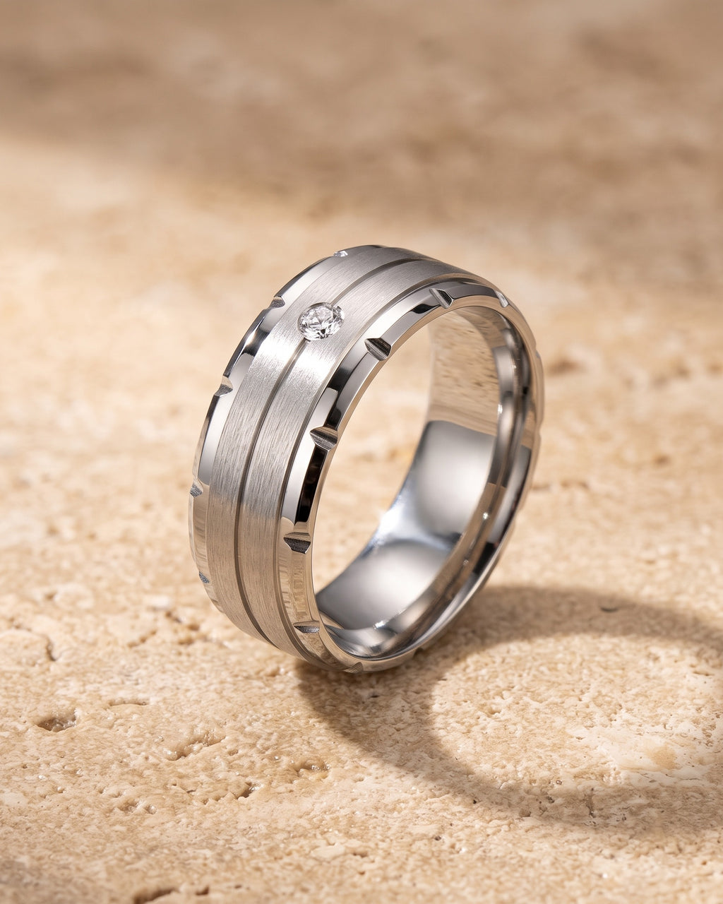 Atlas brushed cubic zirconia band ring standing on warm stone