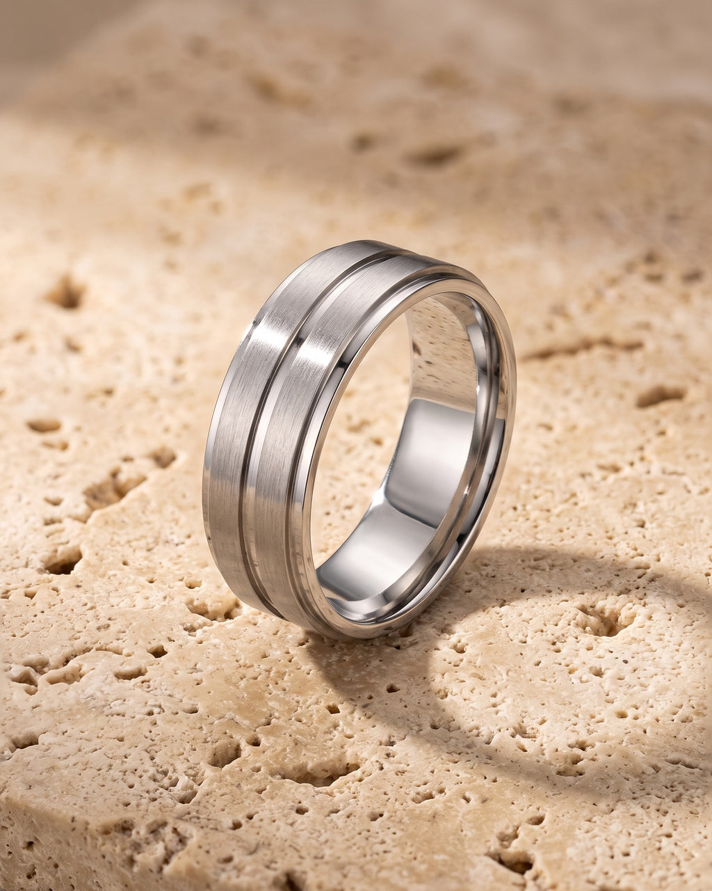 The silver-tone Atlas brushed double groove ring standing on warm stone