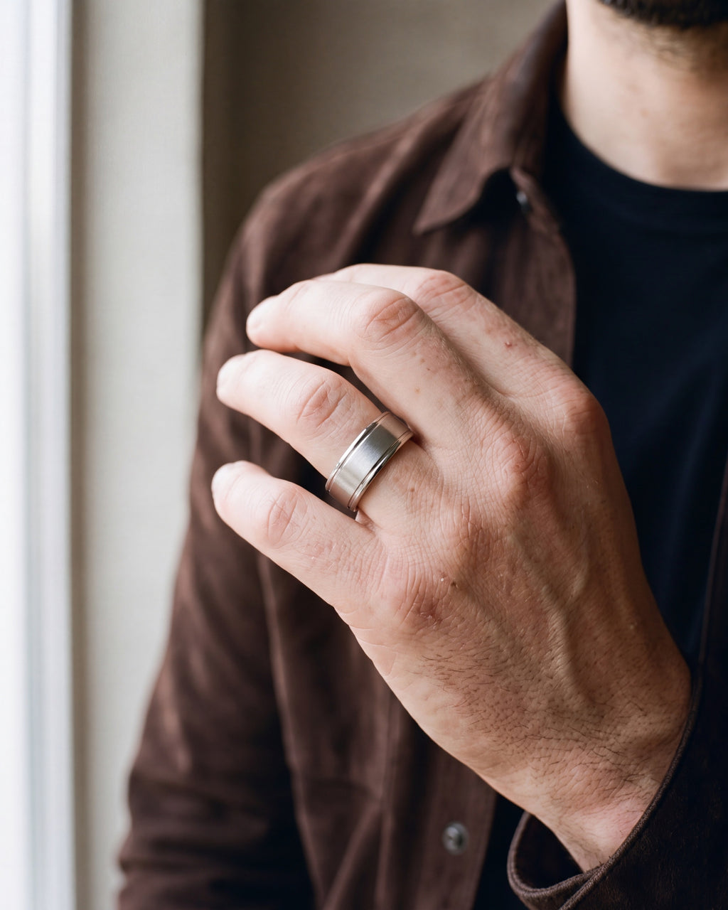 Close-up of the silver-tone Atlas brushed panel ring worn by a man, shown at true size