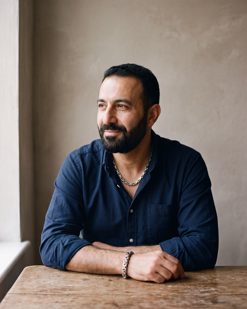 Second man in a dark navy cotton oxford shirt worn open at the collar (two buttons open) wearing the silver Atlas byzantine chain and bracelet set