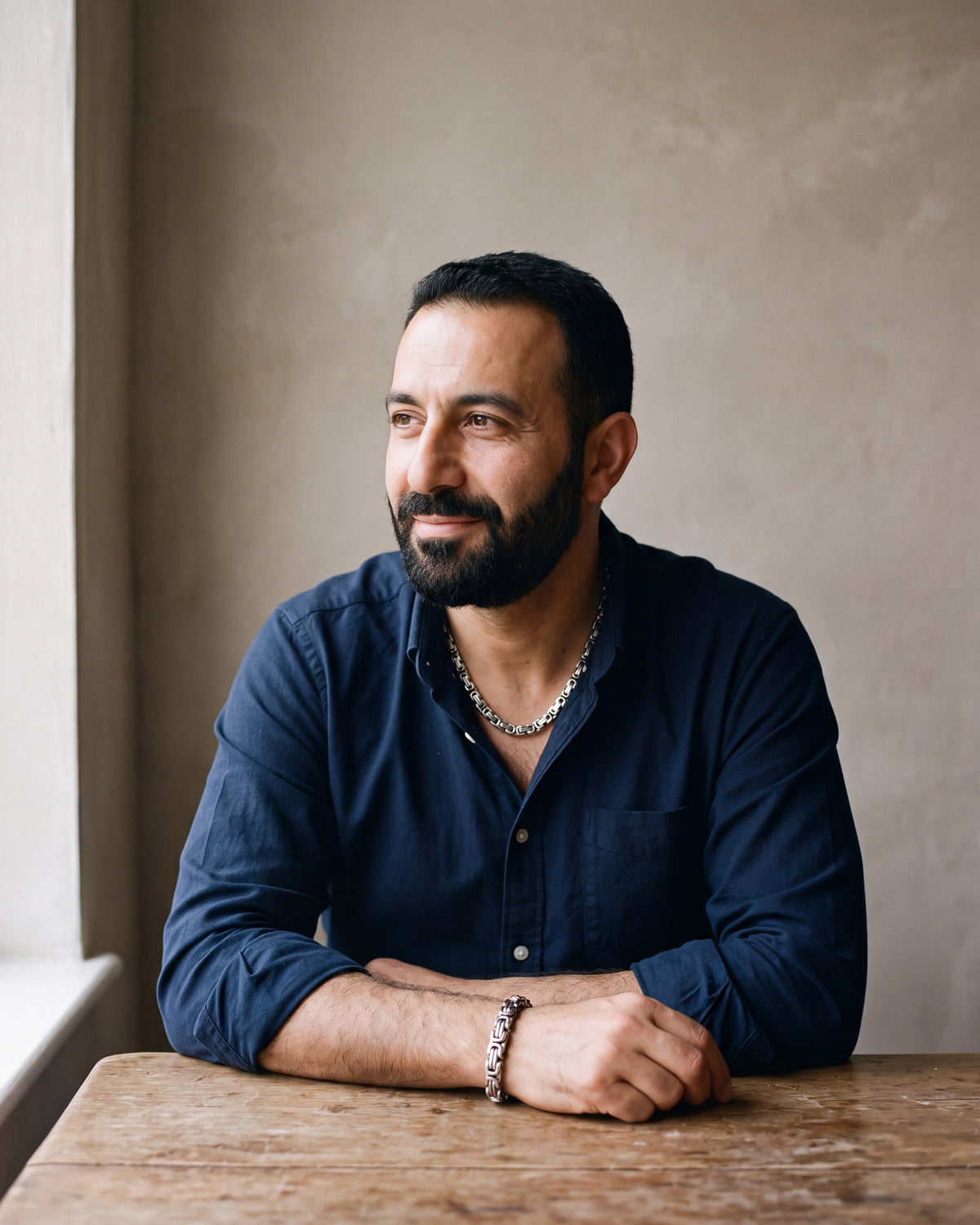 Second man in a dark navy cotton oxford shirt worn open at the collar (two buttons open) wearing the silver Atlas byzantine chain and bracelet set