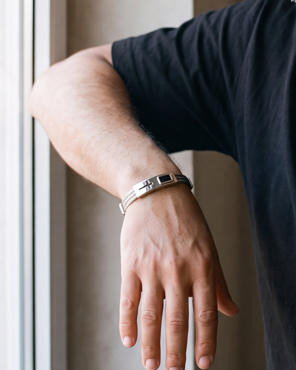 Close-up of the silver Atlas cable cross bracelet on a man's wrist