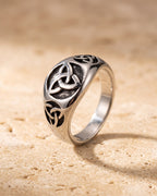 The whole silver-tone Atlas celtic knot ring lying on warm travertine stone