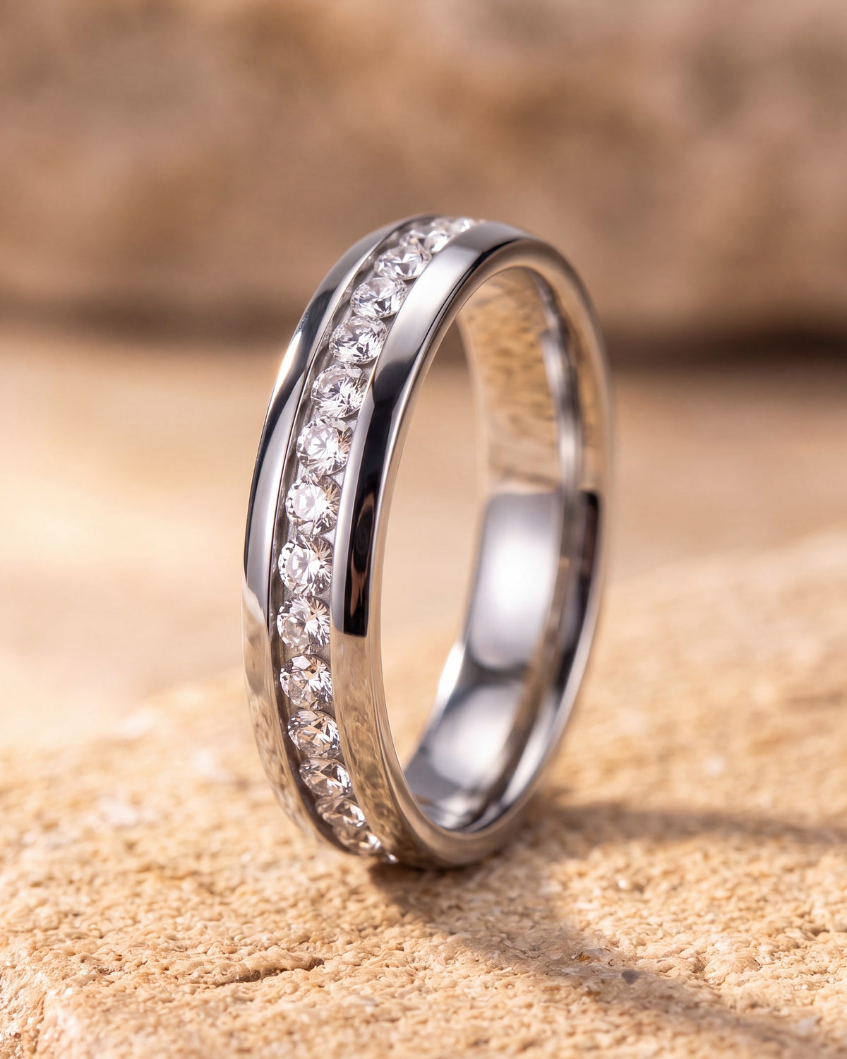 Silver Atlas cubic zirconia band ring standing on warm stone, showing the continuous channel of stones between polished rails