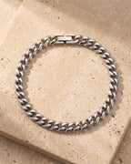 The whole silver-tone Atlas classic Cuban link bracelet laid on warm stone
