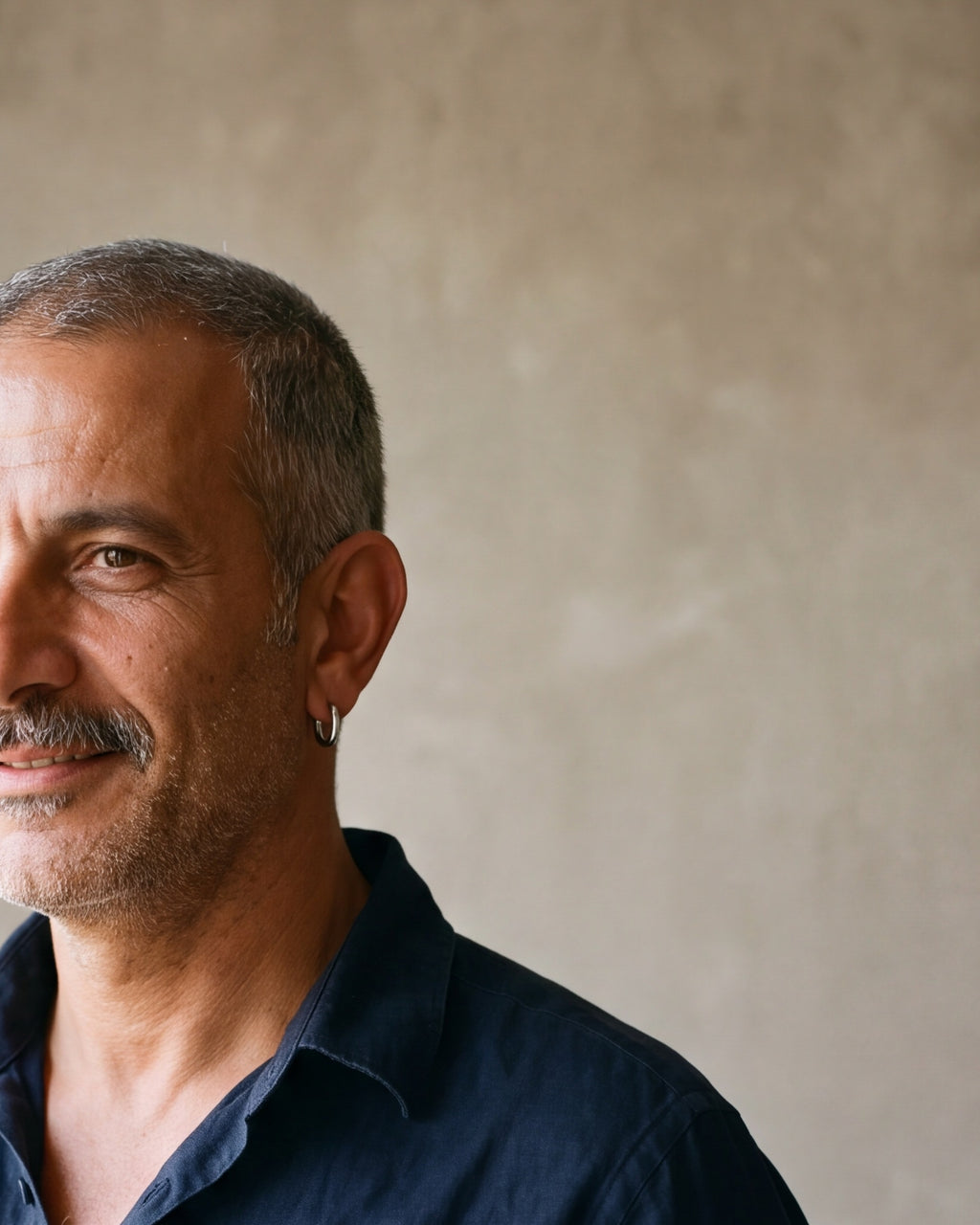Close-up of the silver-tone Atlas classic hoop earring on a man's ear