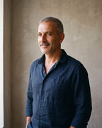 Man in a navy shirt by a window wearing a silver-tone Atlas classic hoop earring