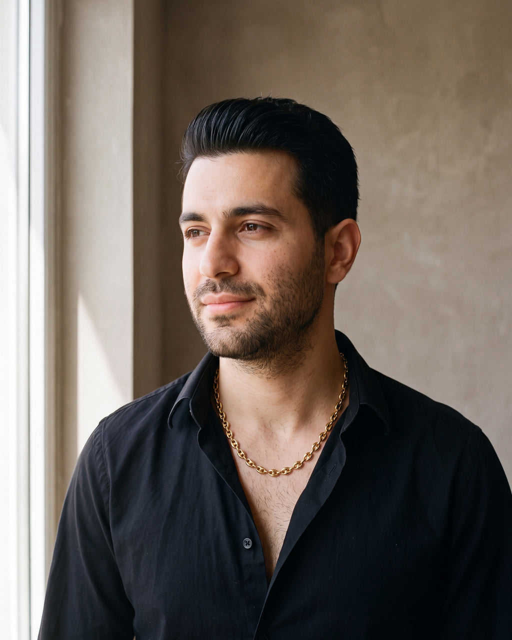 Man in a black fine cotton shirt wearing the gold-tone Atlas Coffee Bean Chain
