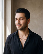 Man in a black fine cotton shirt wearing the gold-tone Atlas Coffee Bean Chain