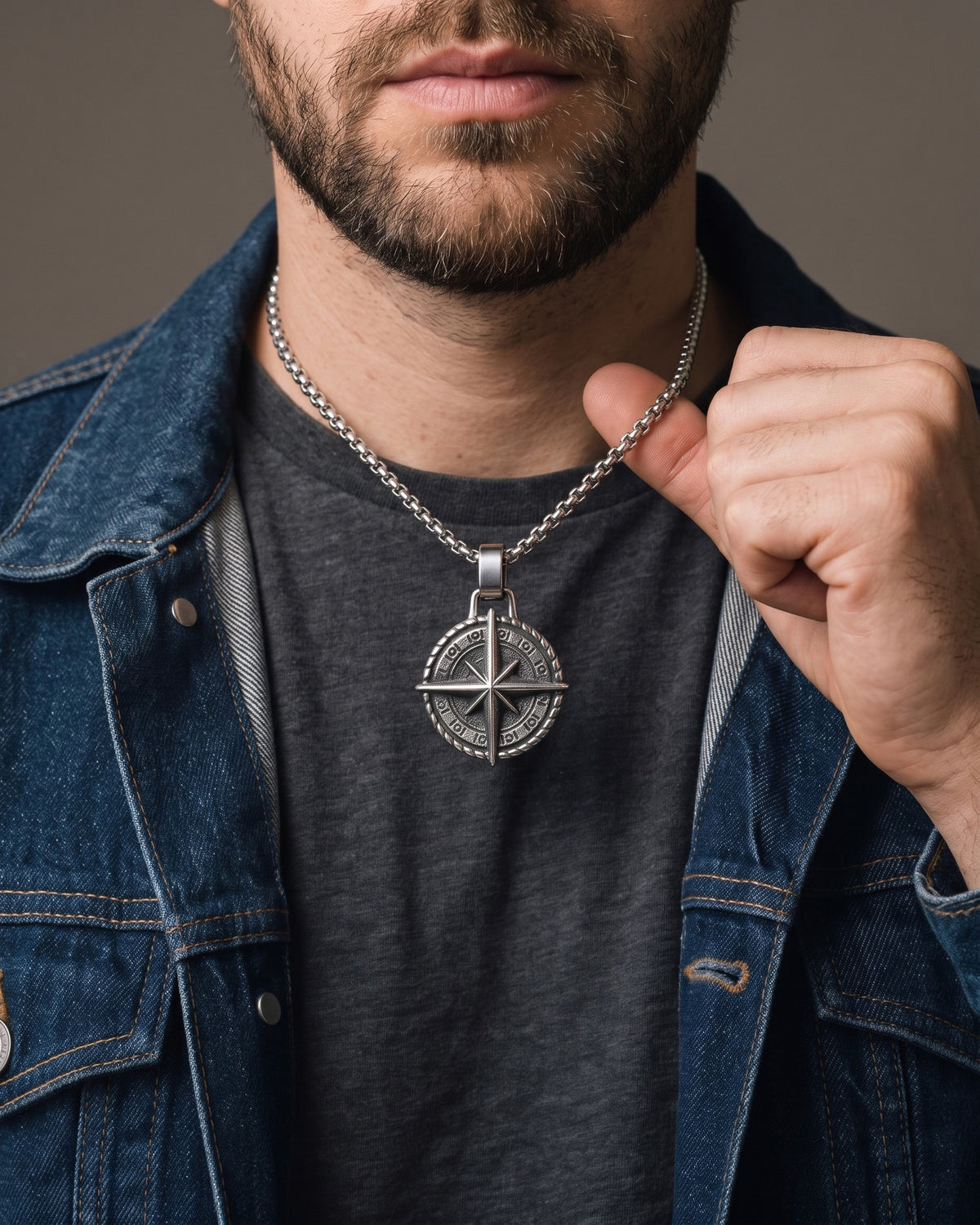 Hand lifting the Atlas Compass Pendant Necklace in Steel at the collarbone