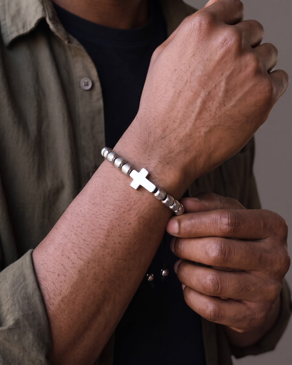 Hand adjusting the Atlas Cross Bead Bracelet on the wrist