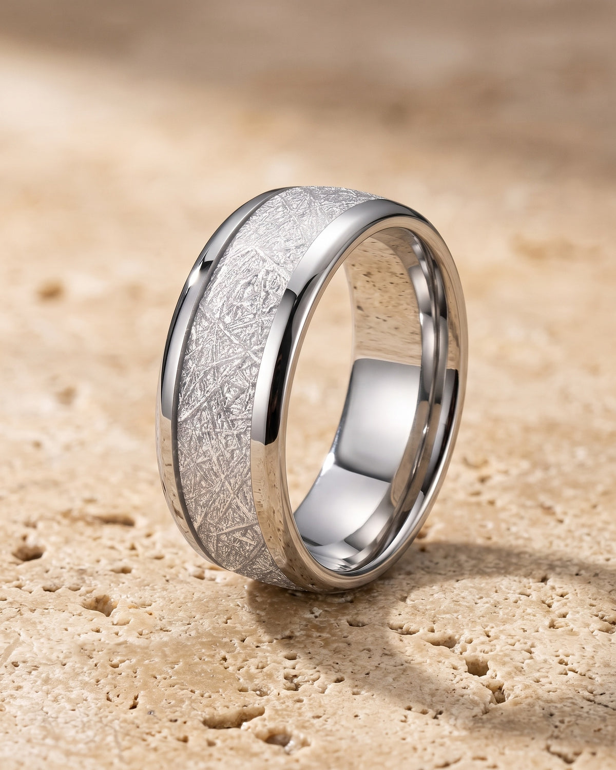 The whole silver-tone Atlas Crosshatch Inlay Dome Ring lying on warm travertine stone