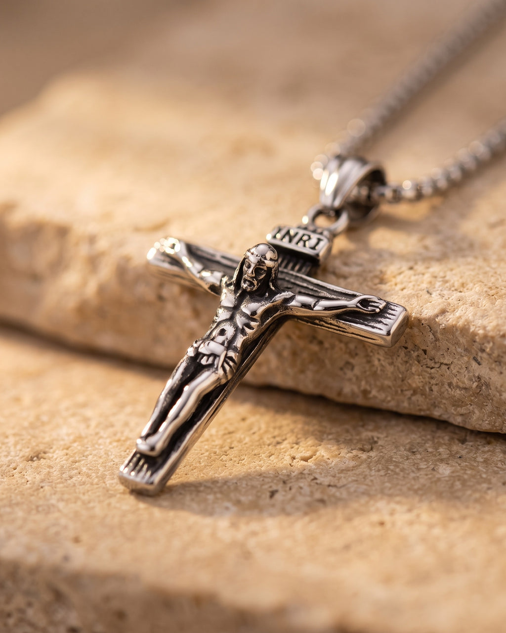 Close-up of the Atlas crucifix pendant relief on warm stone