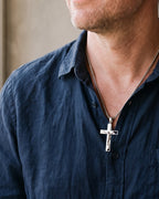 Close-up of the silver-tone Atlas engraved crucifix pendant necklace worn, true size