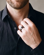 Close-up of the Atlas crushed metal inlay ring in black steel, worn at true size