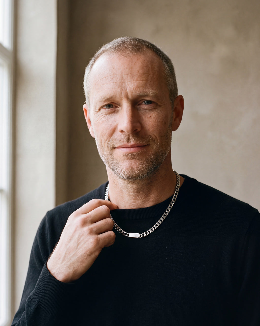 Man in a black merino sweater wearing the silver Atlas Cuban bar chain