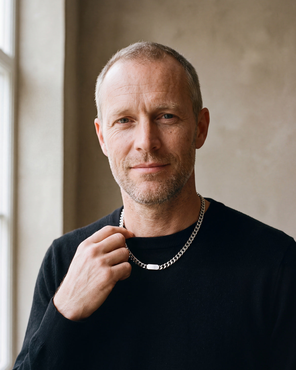 Man in a black merino sweater wearing the silver Atlas Cuban bar chain
