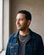 Man in a dark indigo denim jacket open over a charcoal crew-neck t-shirt wearing the gold-tone Atlas Cuban Chain