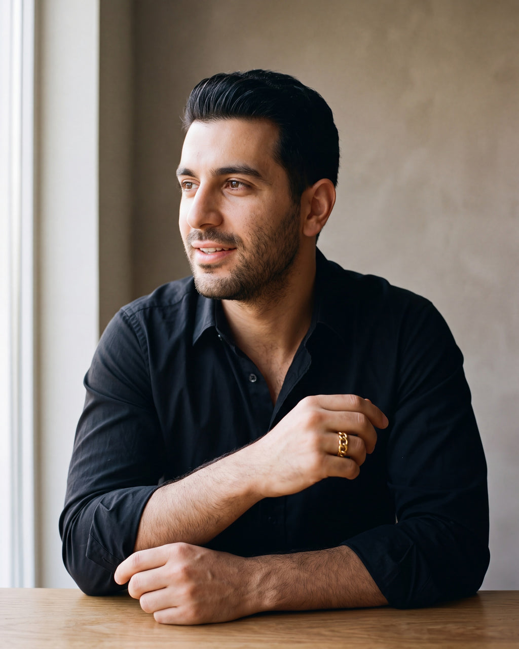 Man in a black fine cotton shirt wearing the gold-tone Atlas Cuban Chain Ring