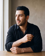 Man in a black fine cotton shirt wearing the gold-tone Atlas Cuban Chain Ring