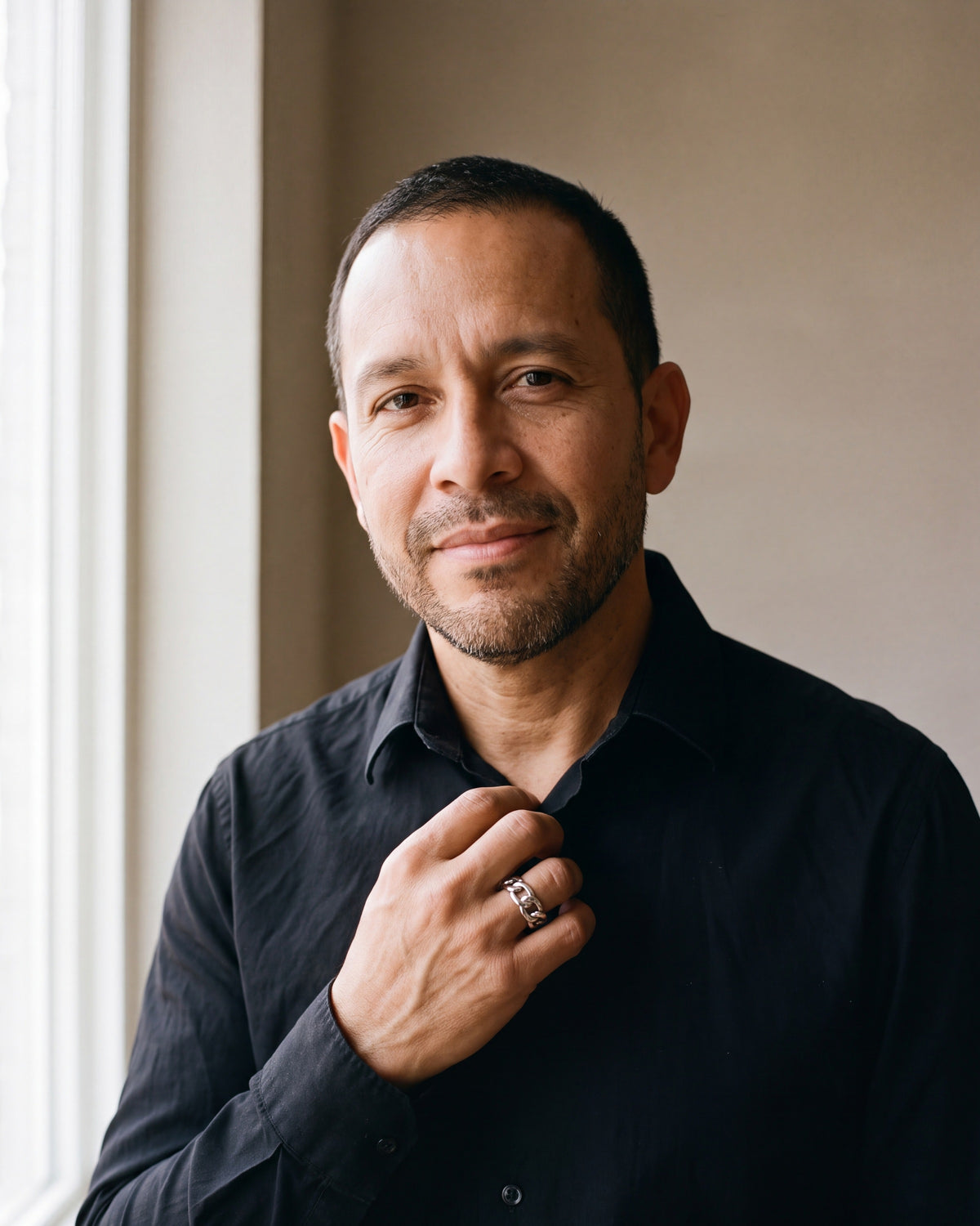 Man in a black fine cotton shirt by a window wearing the silver-tone Atlas Cuban Chain Ring