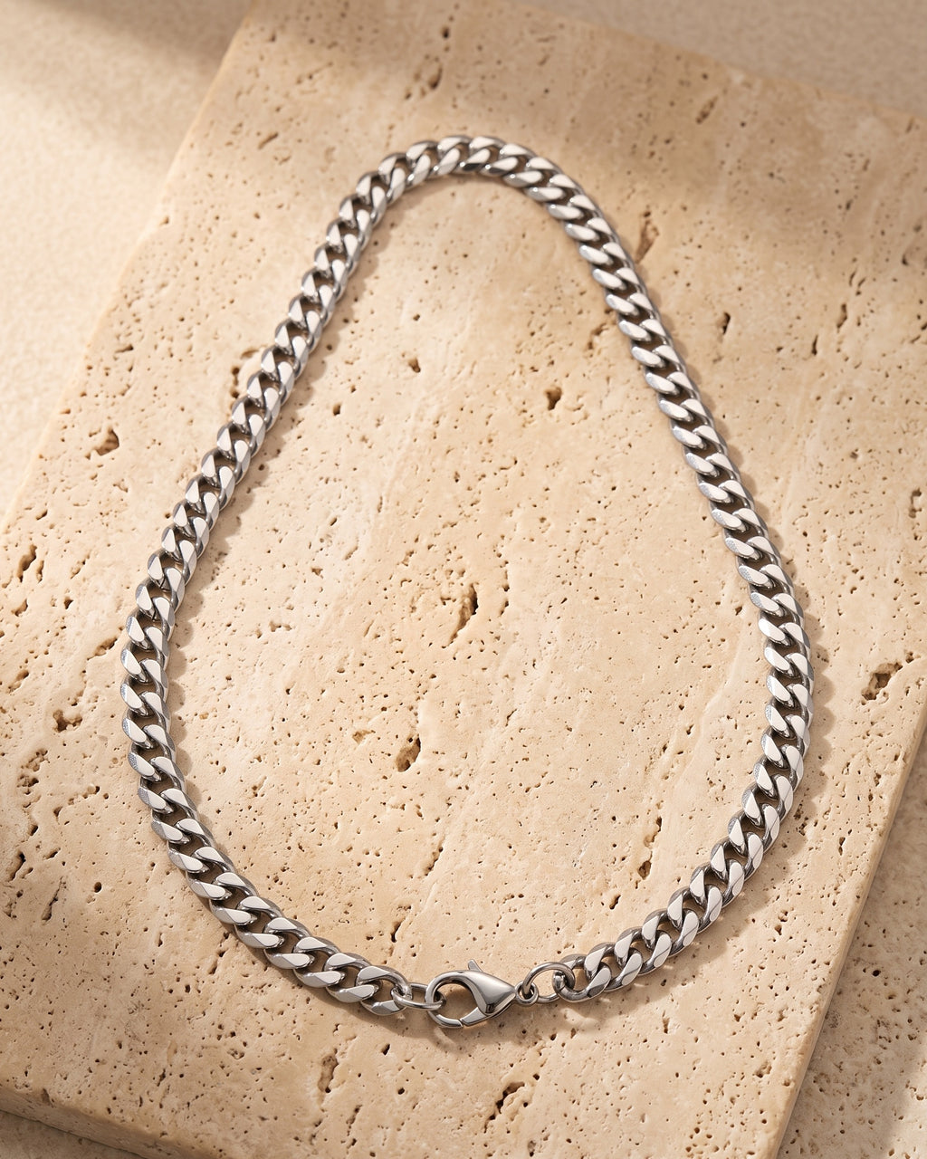 Atlas titanium steel Cuban chain laid whole on warm stone