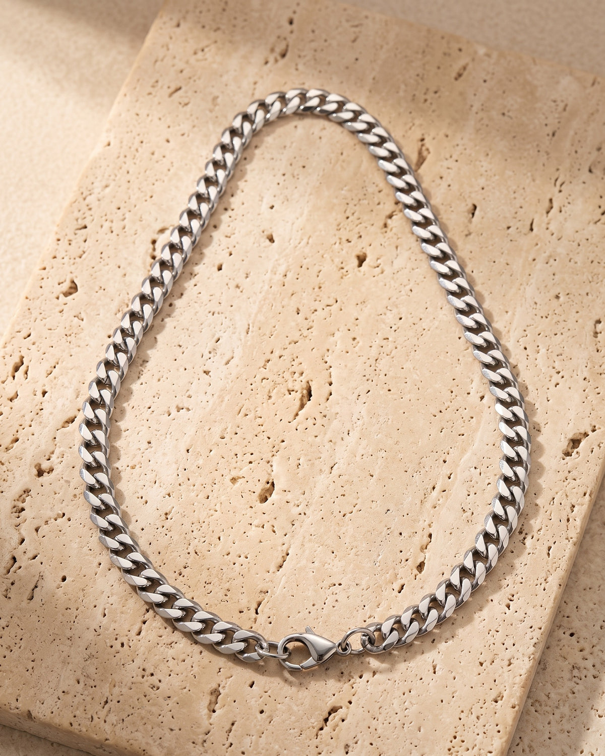 Atlas titanium steel Cuban chain laid whole on warm stone