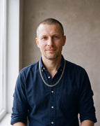 Man in a dark navy cotton oxford shirt by a window wearing the silver Atlas Cuban Chain