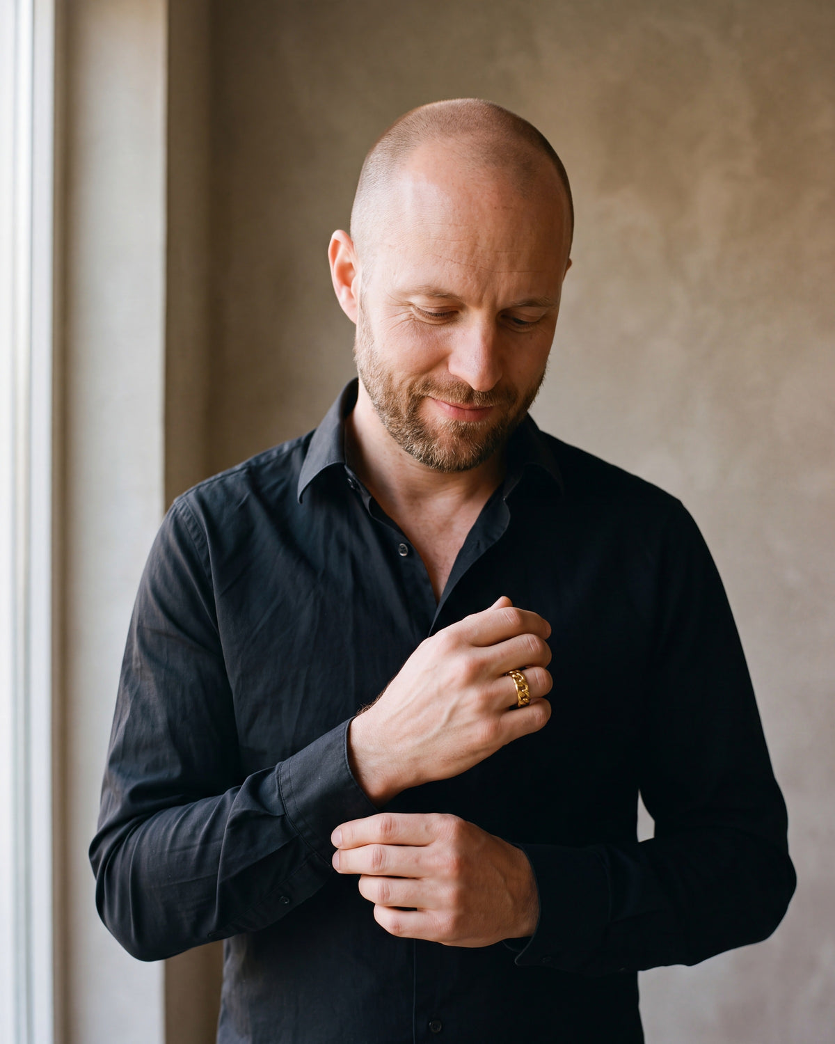 Man in a black shirt wearing the Atlas Cuban link band ring in gold-tone steel
