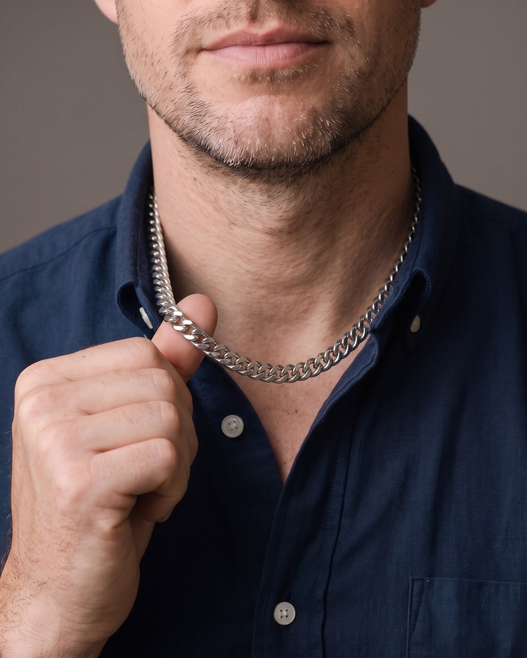 Hand lifting the Atlas Cuban Link Chain in Stainless Steel at the collarbone