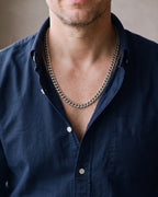 Close-up of the silver Atlas Cuban Link Chain in Stainless Steel worn by a man, shown at true size