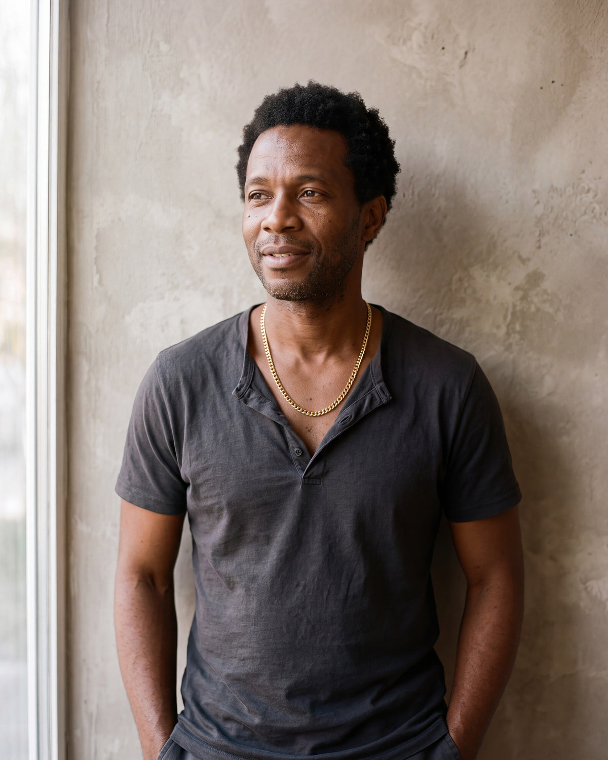 Man in a charcoal henley wearing the Atlas curb chain in gold-tone steel
