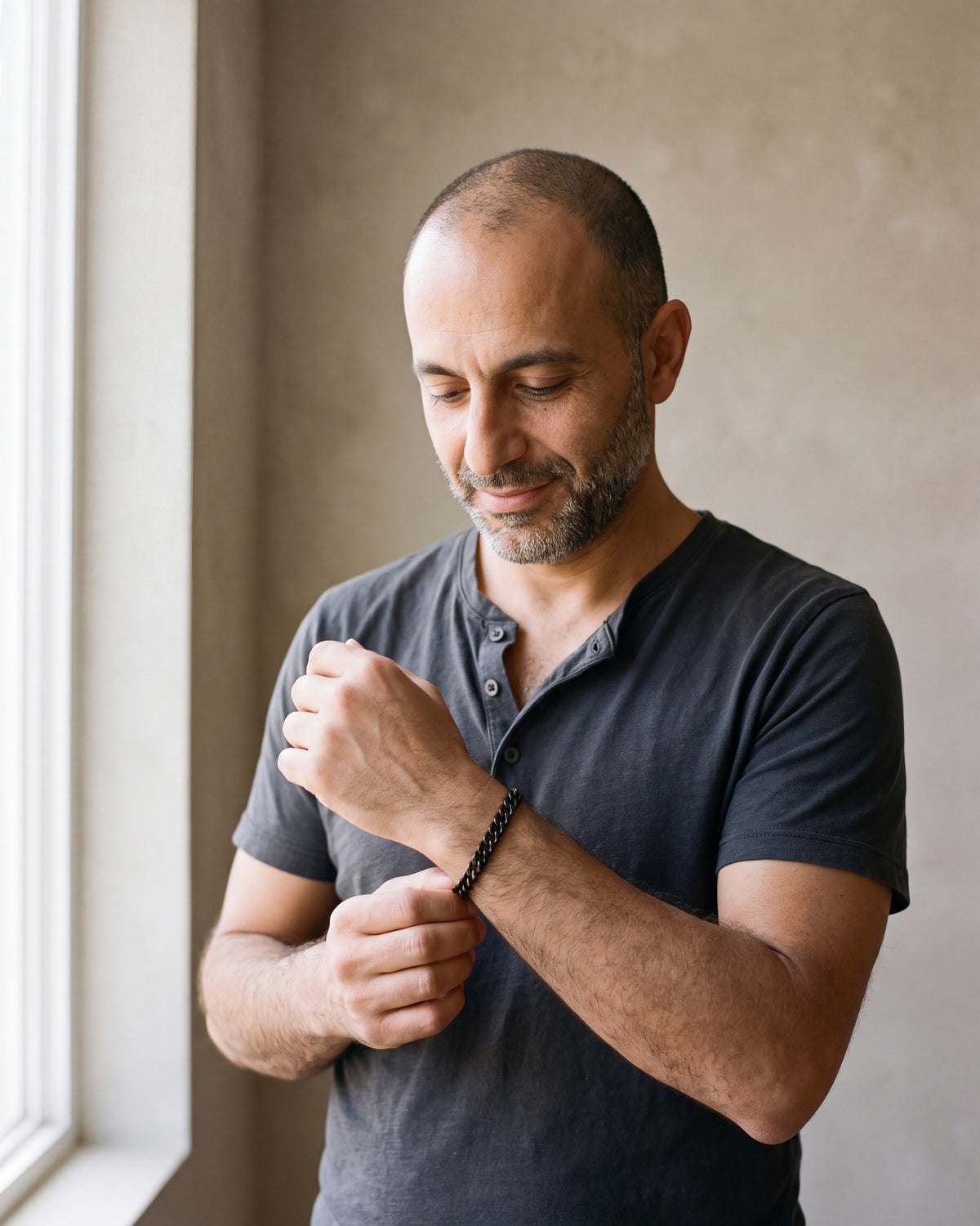 Man in a charcoal henley wearing the Atlas curb link bracelet in black steel