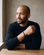 Man in a black merino sweater wearing the Atlas curb link bracelet in black steel