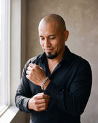 Man in a black shirt by a window wearing the Atlas curb link bracelet in silver-tone steel