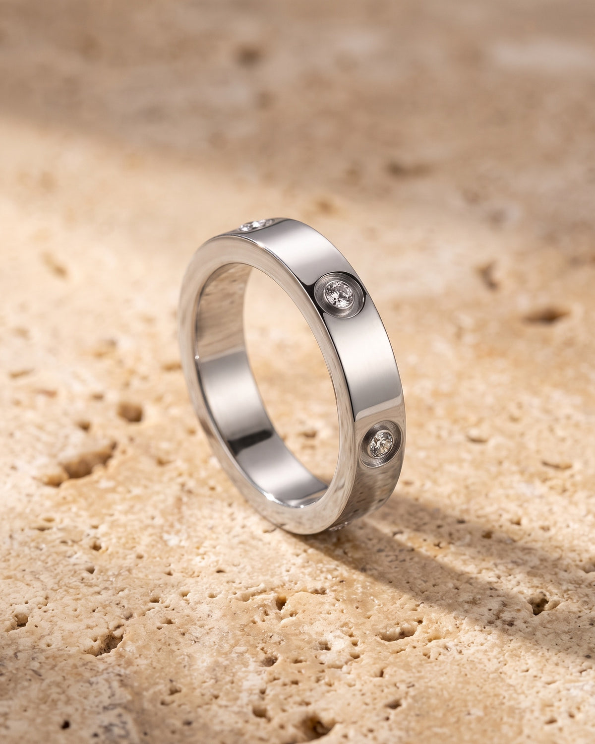 Atlas cubic zirconia band ring standing on warm stone