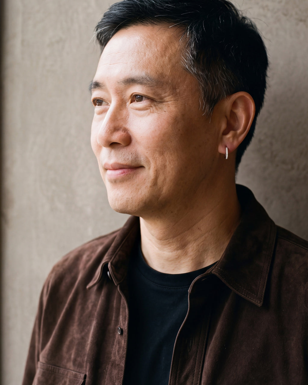 Man in a brown suede overshirt in profile, wearing the 12 mm silver Atlas cubic zirconia hoop earring
