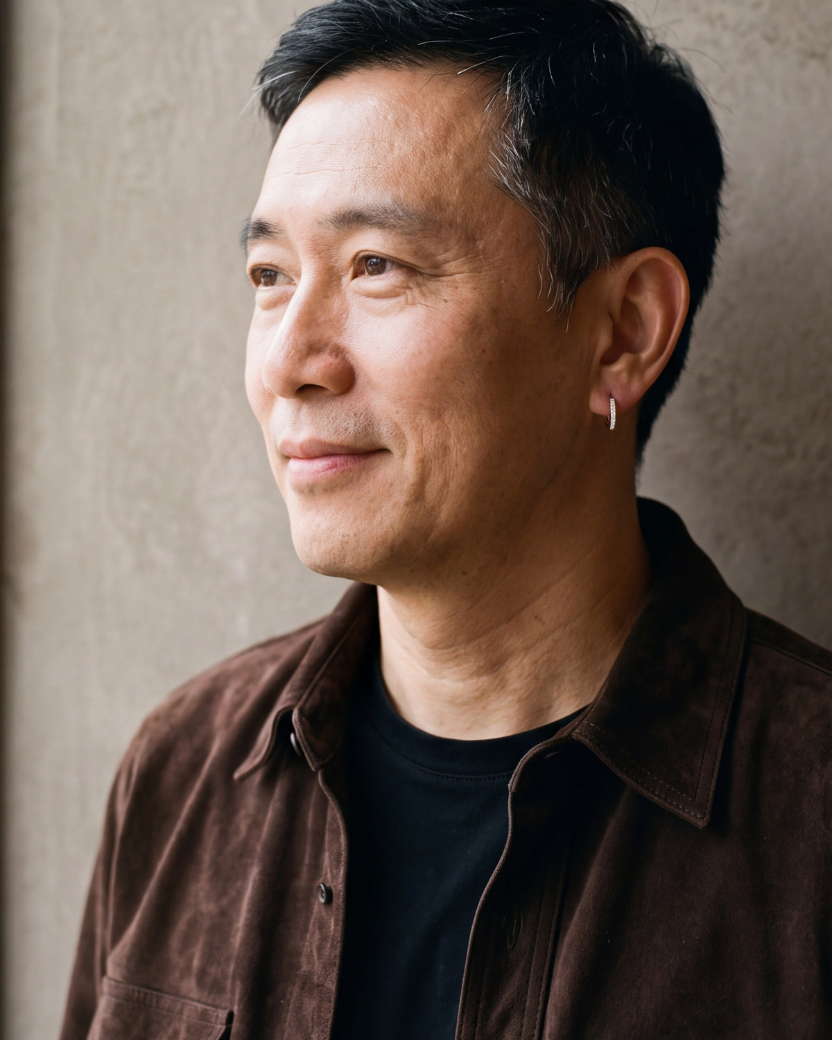 Man in a brown suede overshirt in profile, wearing the 12 mm silver Atlas cubic zirconia hoop earring