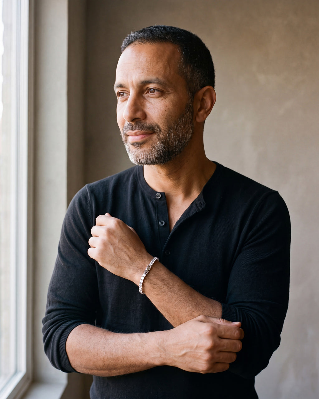 Man in a black henley by a window wearing the silver Atlas CZ tennis bracelet on his wrist