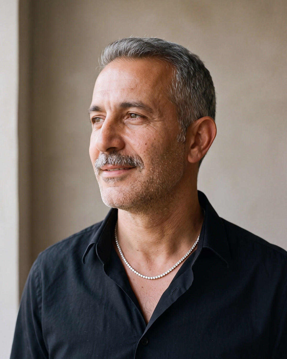 Man in a black shirt by a window wearing the silver Atlas CZ tennis chain