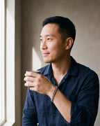 Man in a dark navy linen shirt by a window wearing the silver-tone Atlas Diamond-Cut Cuban Bracelet