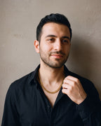Man in a black fine cotton shirt by a window wearing the gold-tone Atlas Diamond-Cut Cuban Chain
