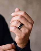 Close-up of a man's hand wearing the Atlas 8 mm double black inlay ring at true size